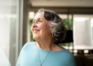 Older woman smiling looking out window